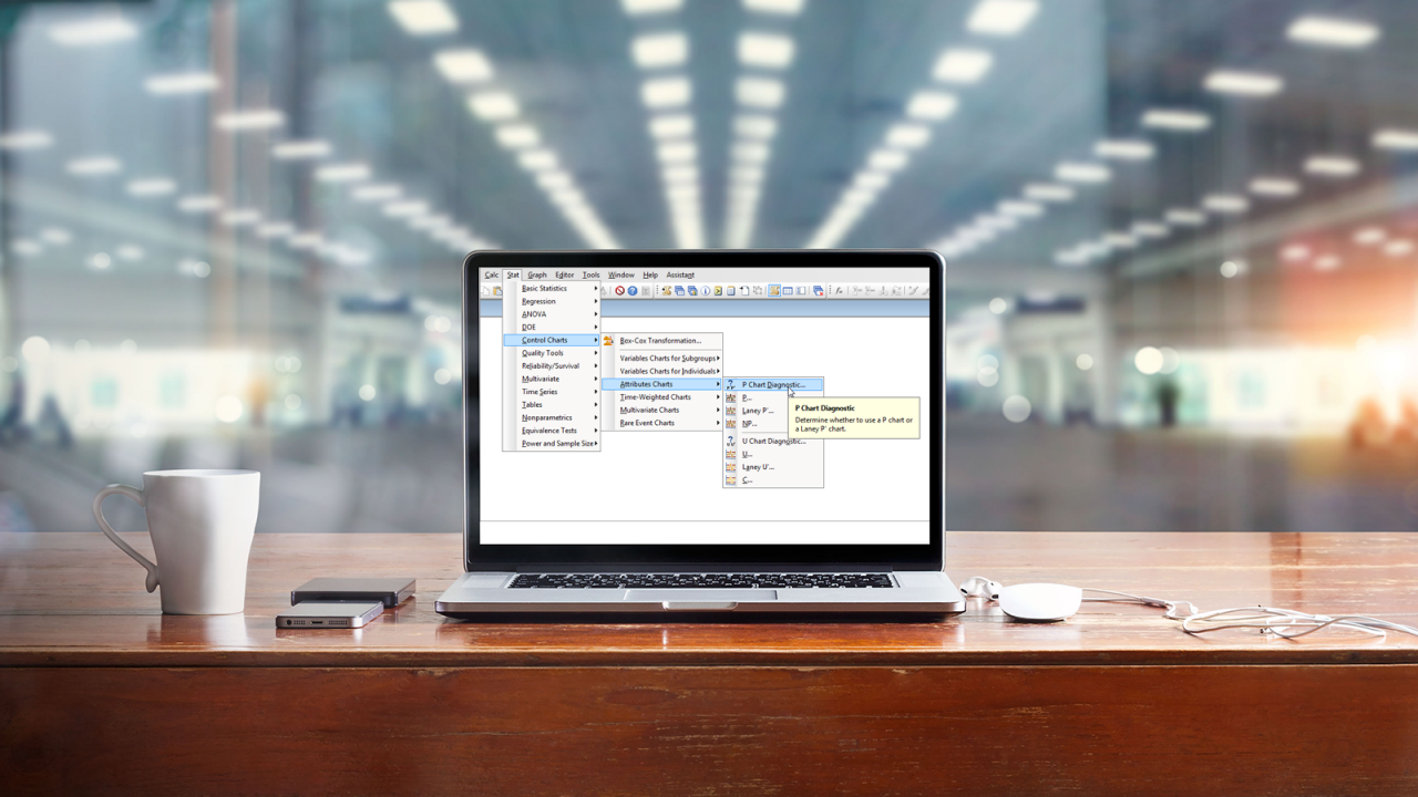 Laptop on table in an office with screen showing ability of Minitab software to perform P chart diagnostics.