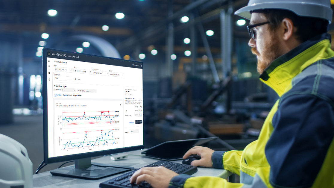 Engineer monitoring processes with real-time data at computer work station.