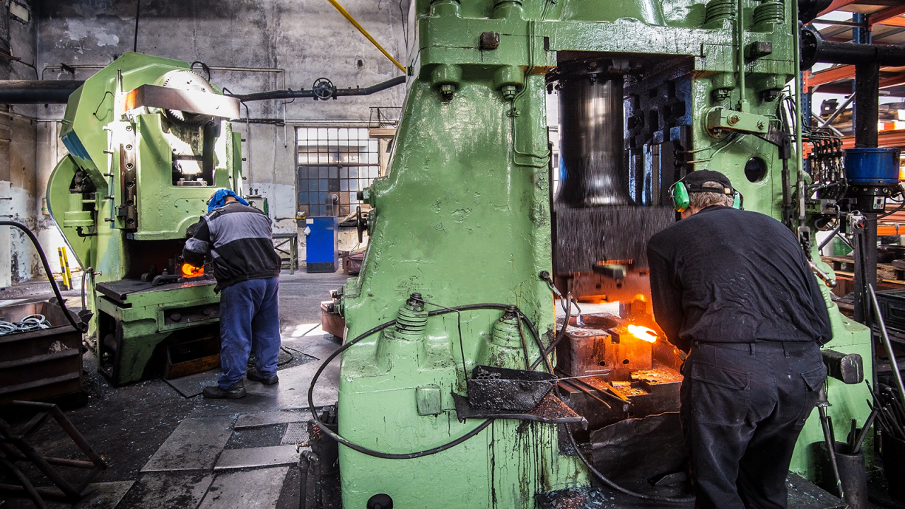 metal forging, forging shop. hydraulic hammer shapes the red-hot billet.